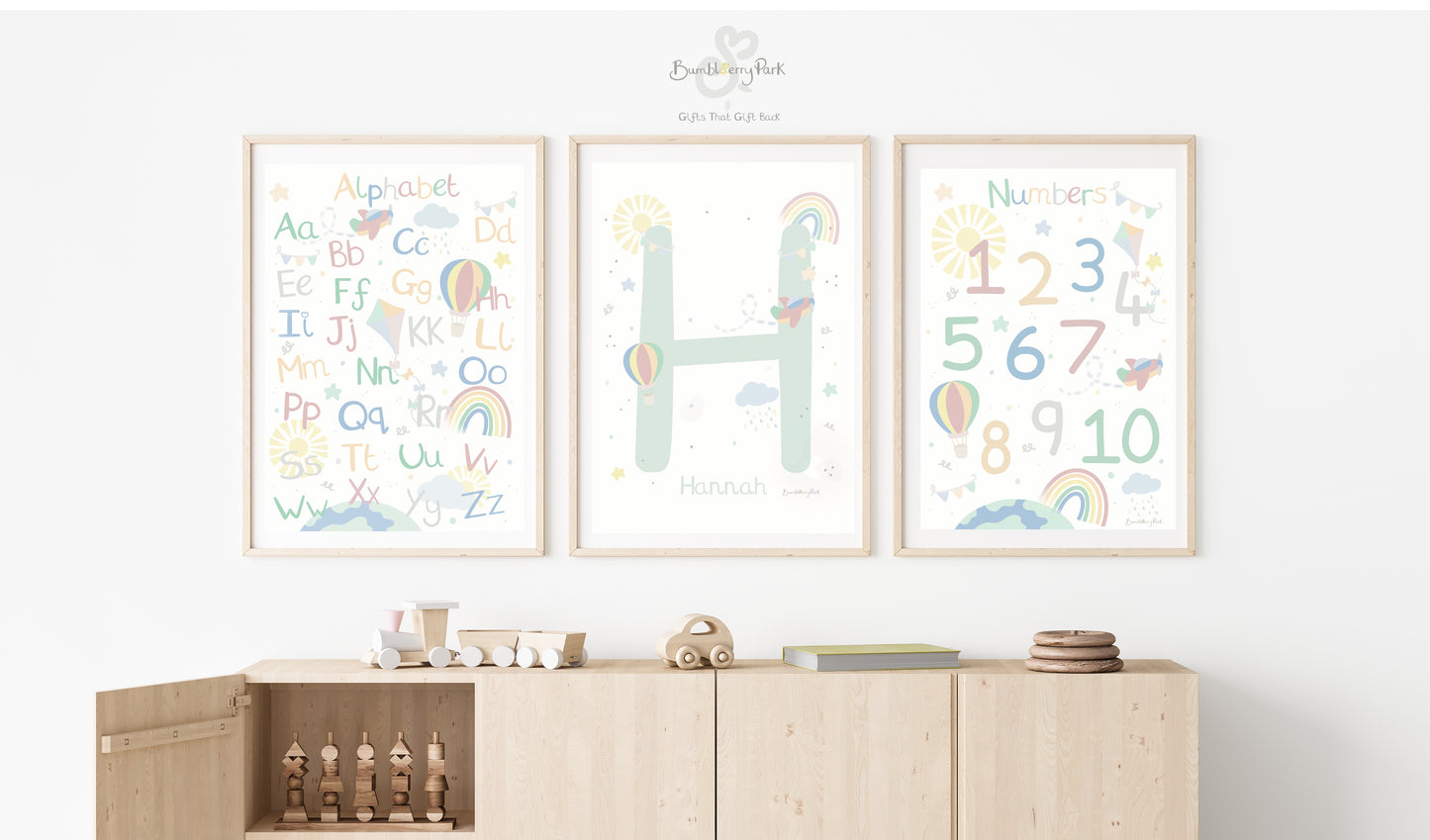 set of three matching rainbow wall prints for children's bedroom. Neutral nursery decor prints with personalised initial letter and name print, with travel and transport theme decor with rainbows, sunshine, hot air balloon and aeroplane features