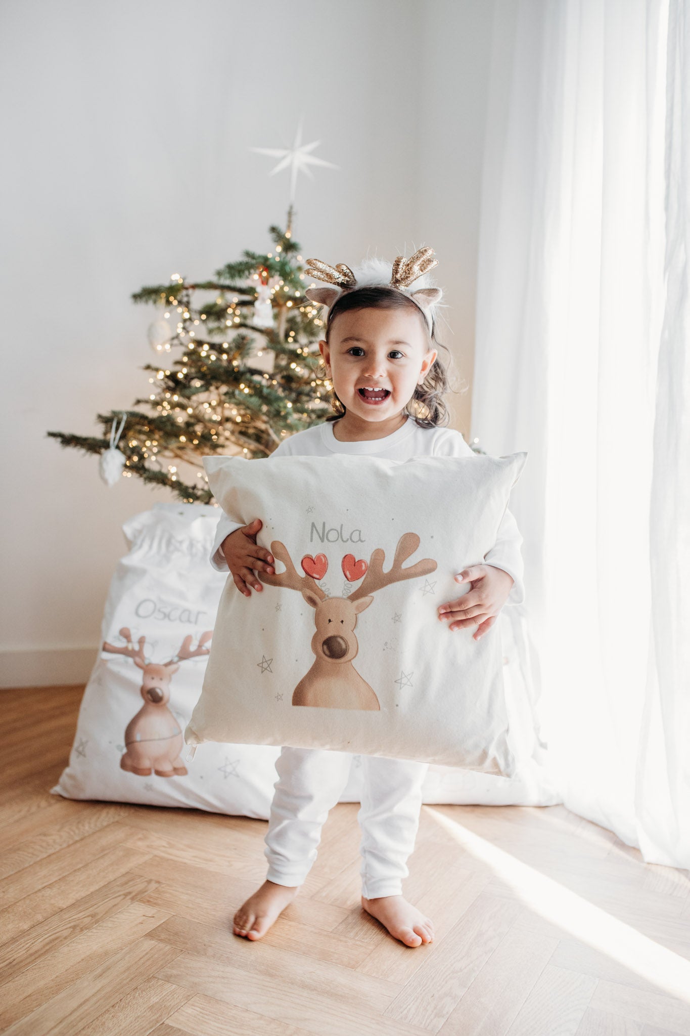 toddler girl holding personalised christmas cushion with hidden pocket