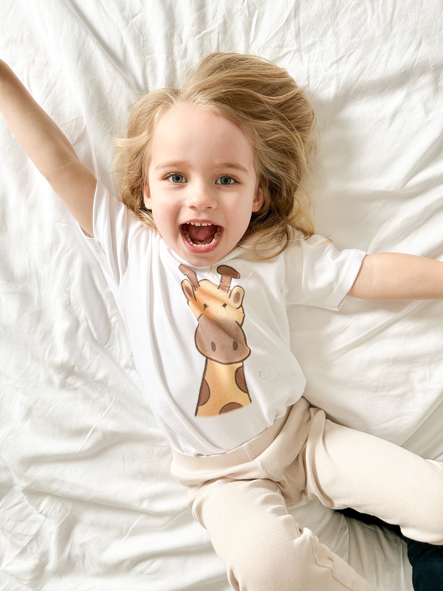 toddler girl wearing giraffe t-shirt and neutral leggings and roaring like a lion