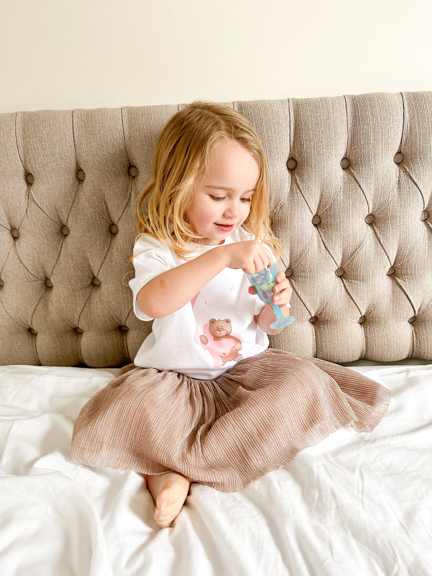 toddler girl eating sweets wearing a 3rd birthday party outift