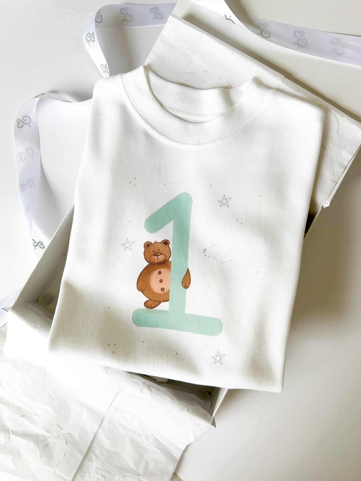 1st birthday keepsake t-shirt printed with a woodland bear design holding the number 1