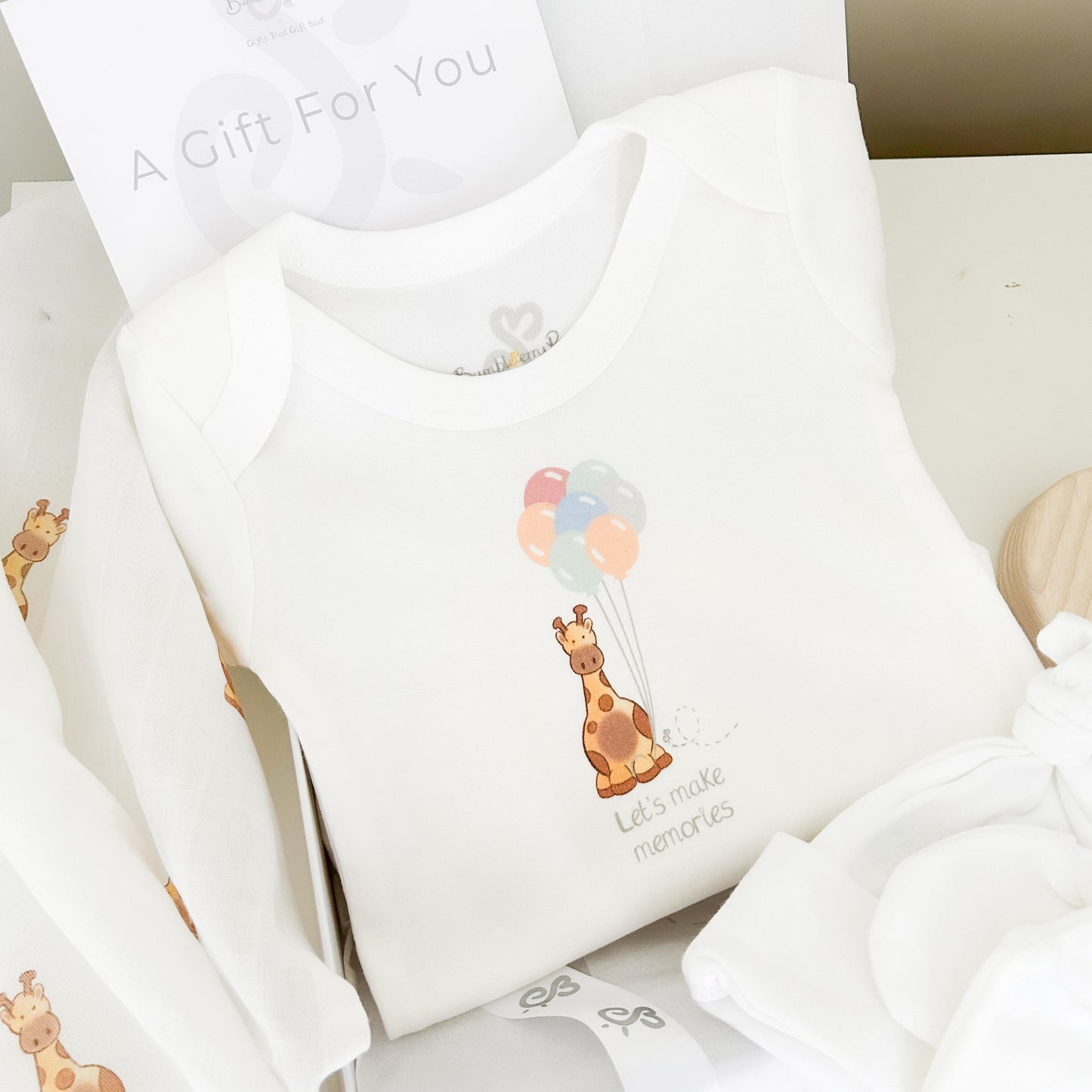 baby bodysuit printed with a giraffe safari balloon party design