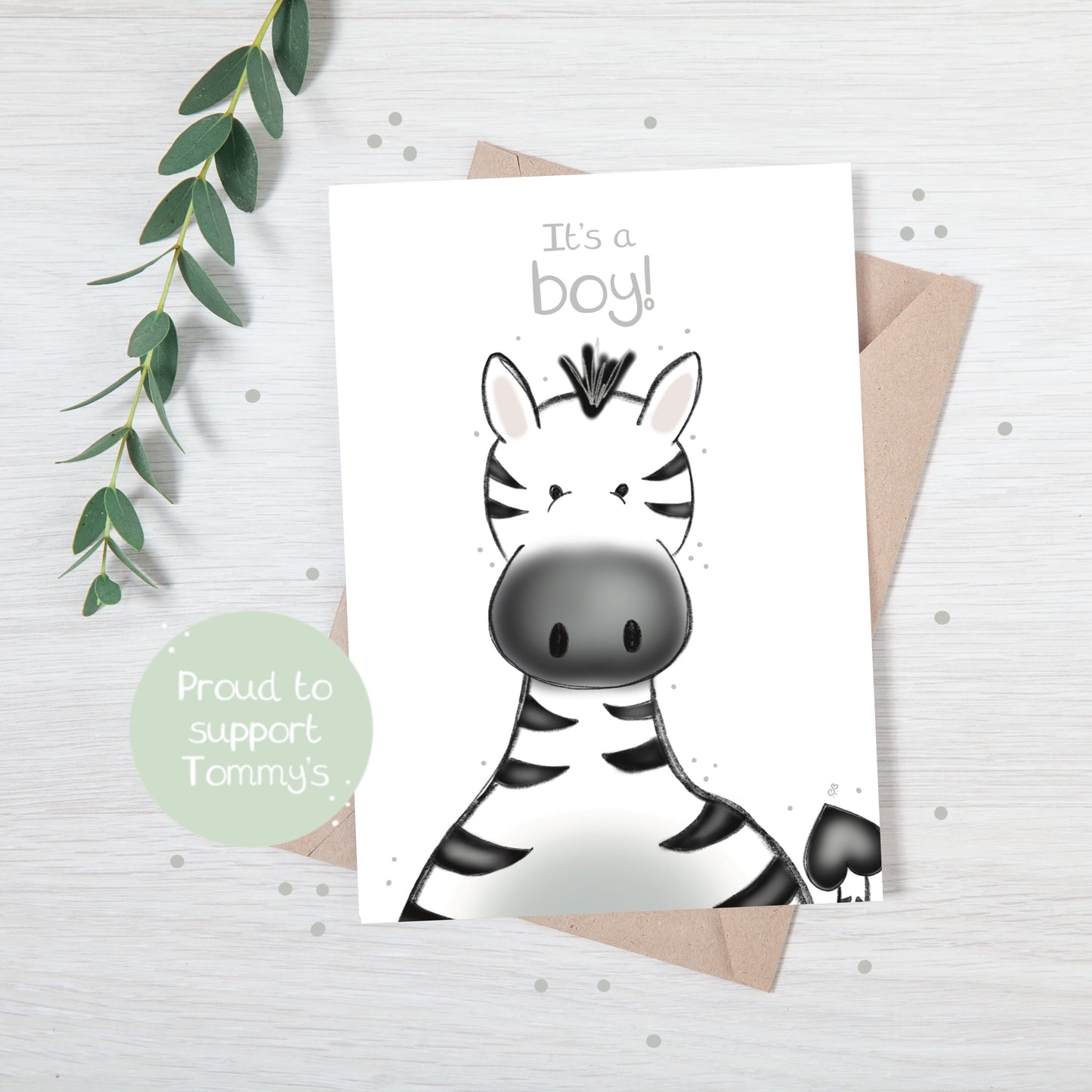 Handmade luxury new baby greetings card with a safari theme baby zebra popping up from the bottom with the title "e "it's a boy" on a white background, with a kraft envelope