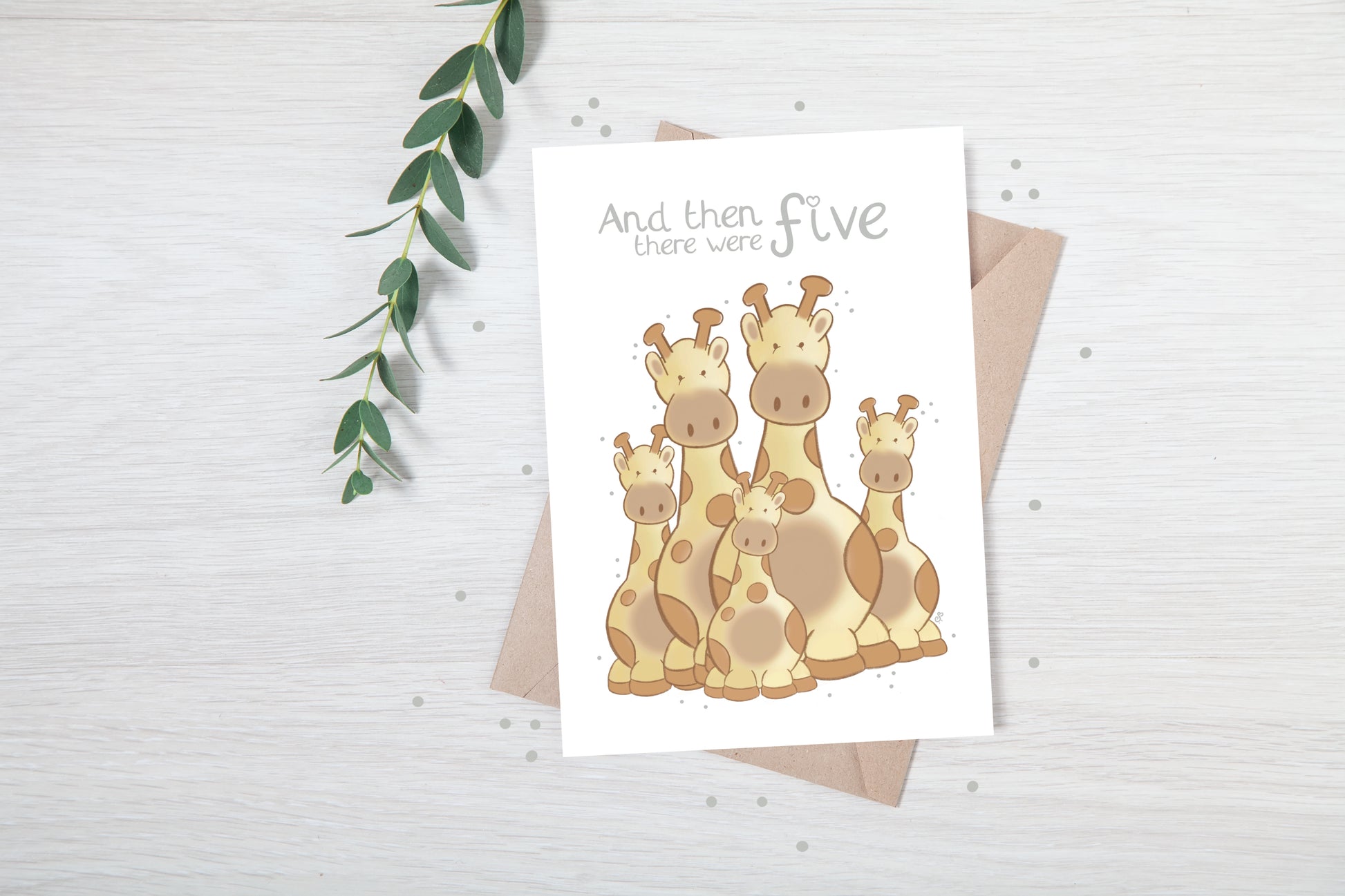 Handmade luxury new baby greetings card with a safari theme with a family of giraffes title &quote "and then there were 5" on a white background, with a kraft envelope