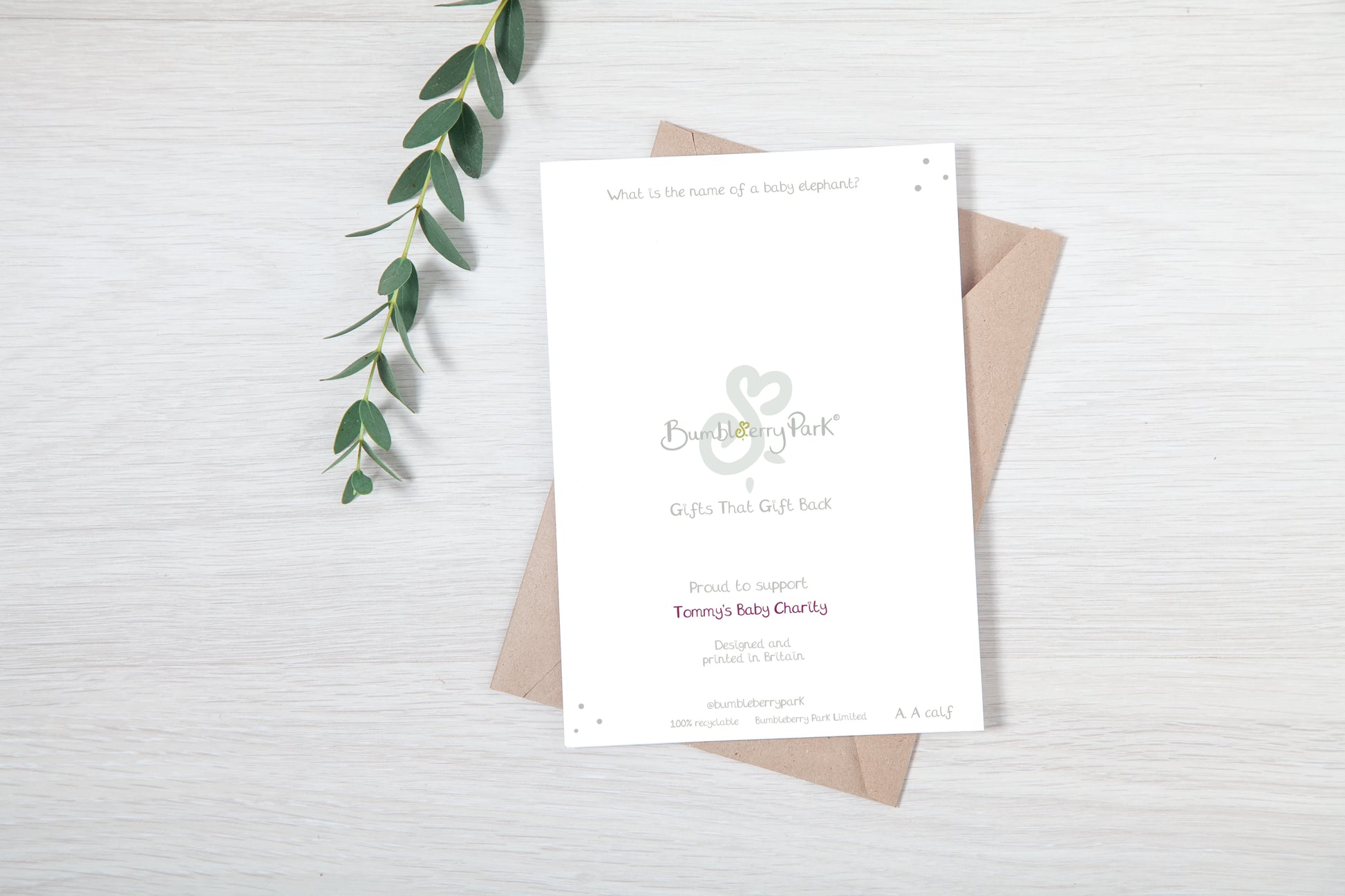 Handmade luxury new baby card with charity donation and made in britain 100% recyclable notes on the back cover on a white background, with a kraft envelope