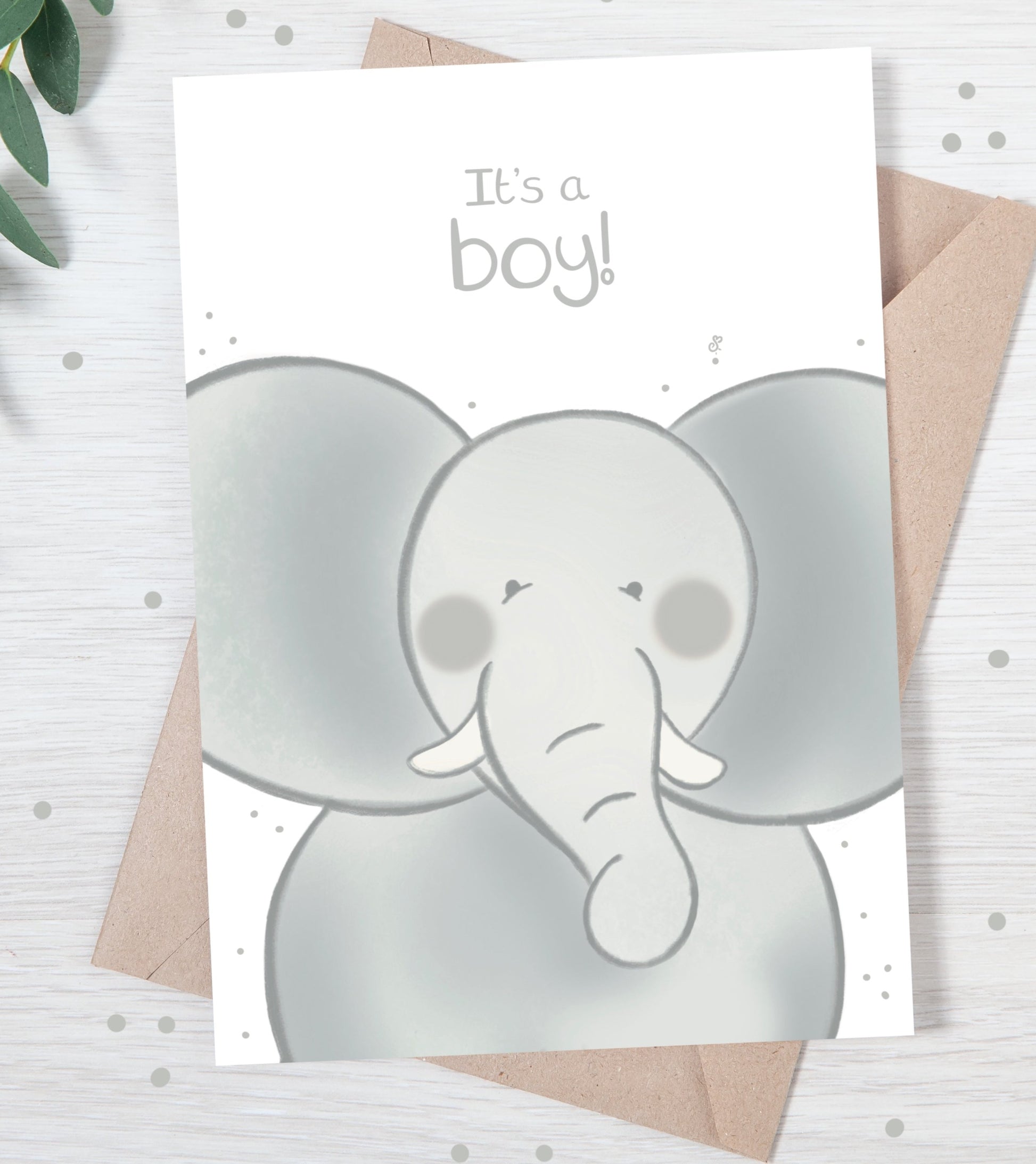 Handmade luxury new baby christening greetings card with a safari theme baby elephant popping up from the bottom with the title &quote "it's a boy" on a white background, with a kraft envelope