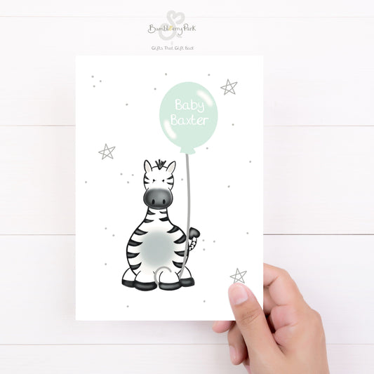 luxury safari new baby card for new baby girl boy as a baby shower gift with a baby zebra holding a green balloon with baby name inside it