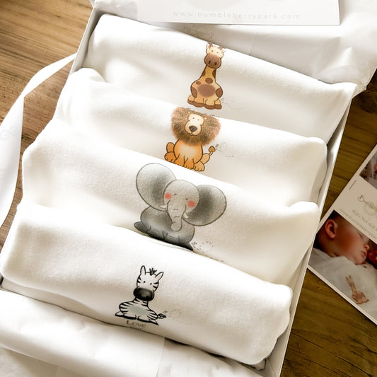 set of 4 baby bodysuits in mixed sizes for baby's first year with safari animal prints and positive messages of inspiration presented in a gift box with white satin ribbon