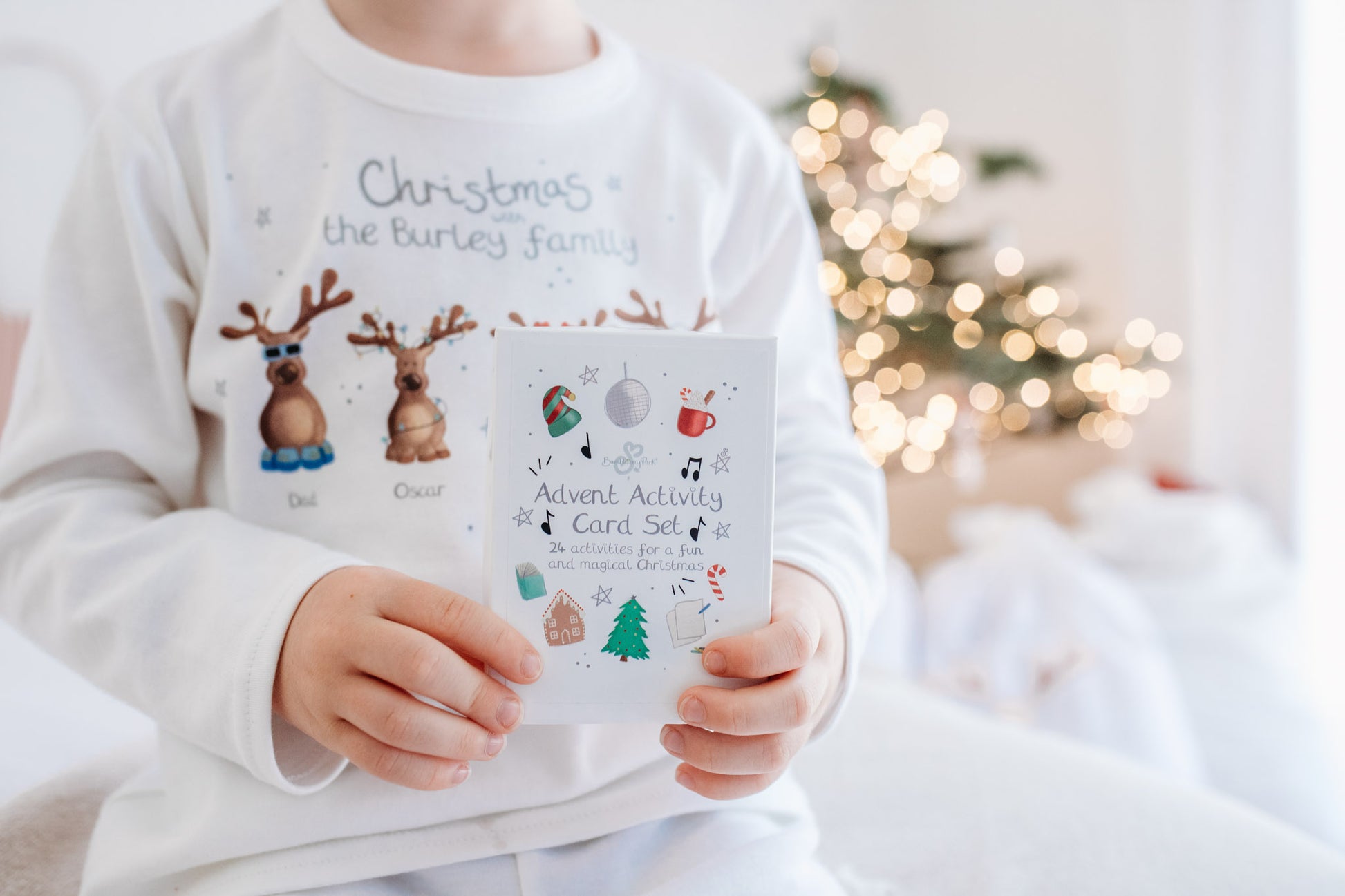 boy holding a card set of Christmas craft activities for kids
