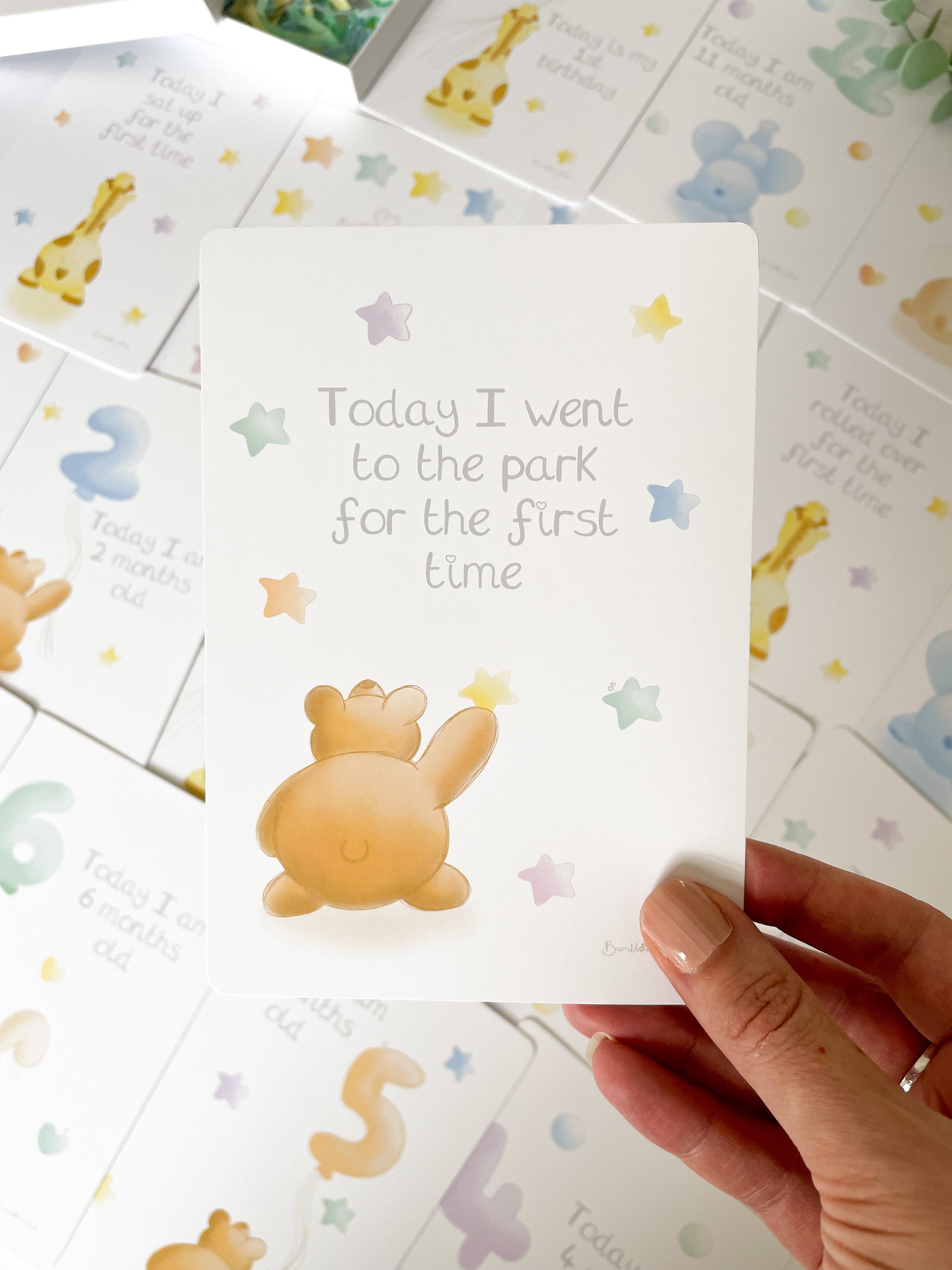 a close up of a baby milestone card with a brown bear reaching for a star, and the milestone "Today I went to the park for the first time"