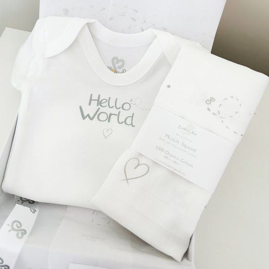 white baby bodysuit with "hello world" print design with matching baby muslin swaddle with soft grey neutral hearts, stars, dots and bees pattern
