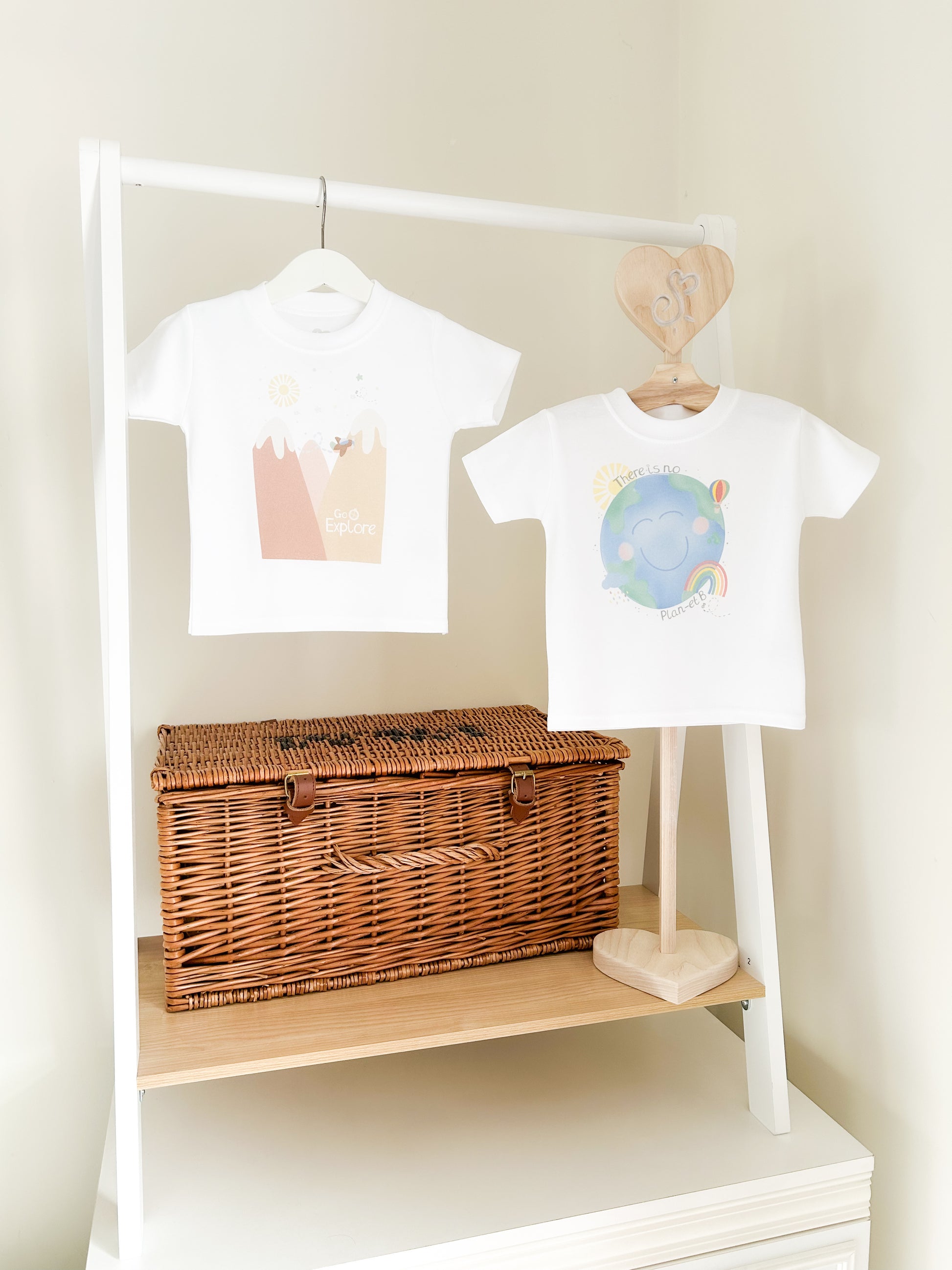 two children's t-shirts with go explore and planet earth neutral prints with the world, and mountains in muted colours