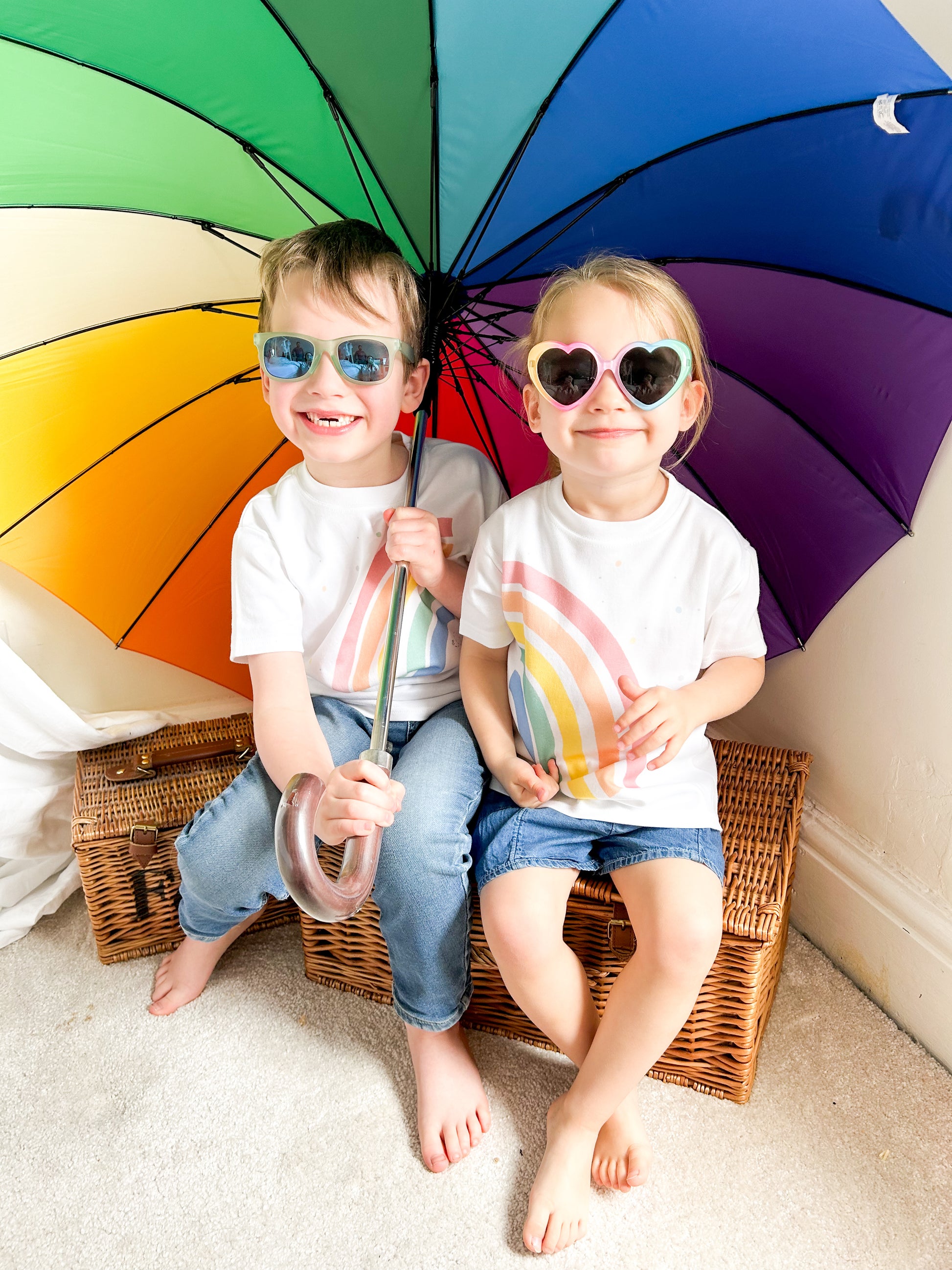 matching holiday outfits for boy and girl wiith bright colourful rainbow design and rianbow colour umbrella