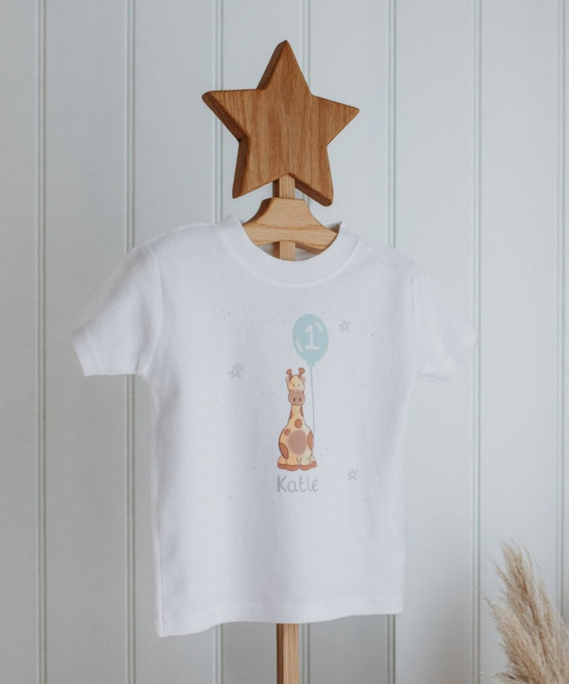 close up of safari animal personalised birthday top for 1st birthday on a wooden baby clothes stand