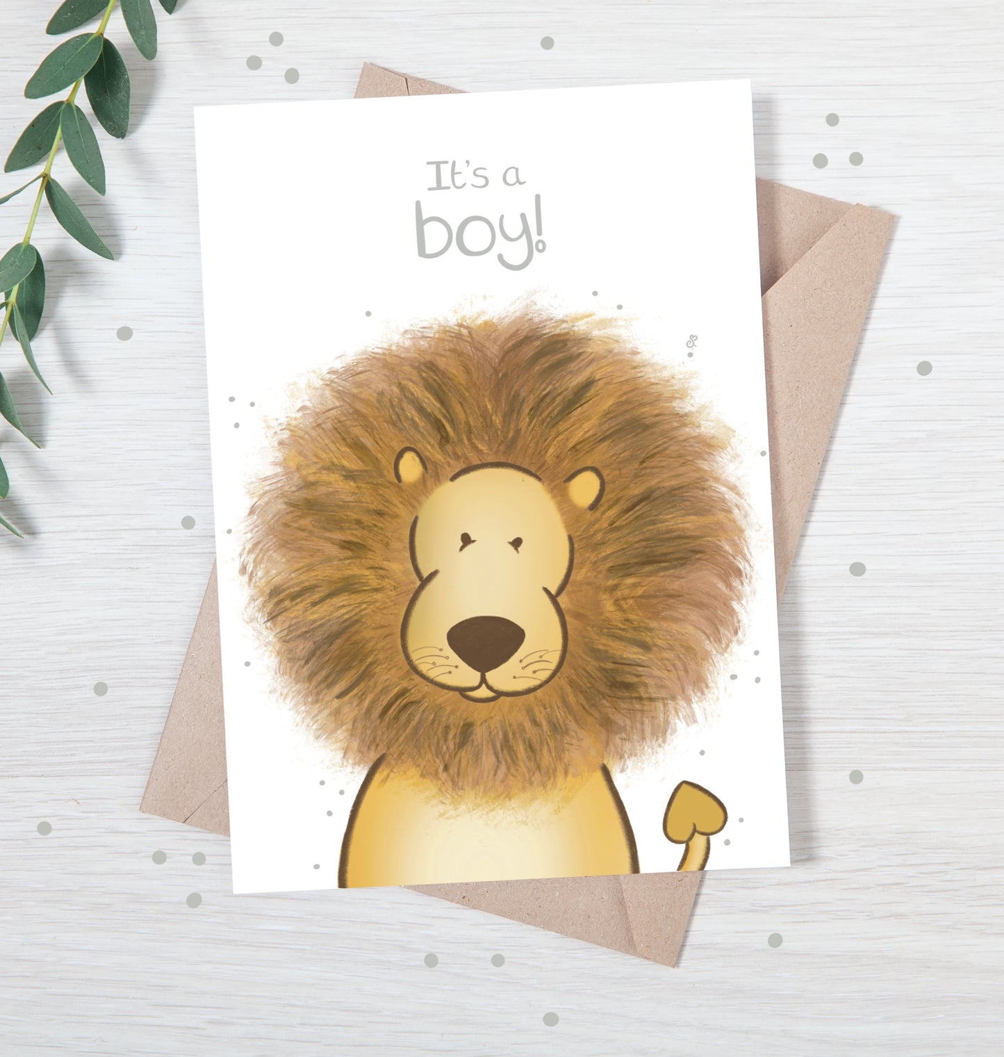 Handmade luxury new baby christening greetings card with a safari theme baby lion popping up from the bottom with the title &quote "it's a boy" on a white background, with a kraft envelope