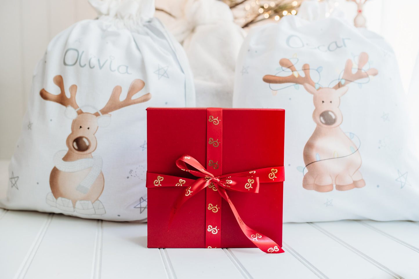 luxury red magnetic gift box wrapped in bumbleberry park sating ribbon under a christmas tree