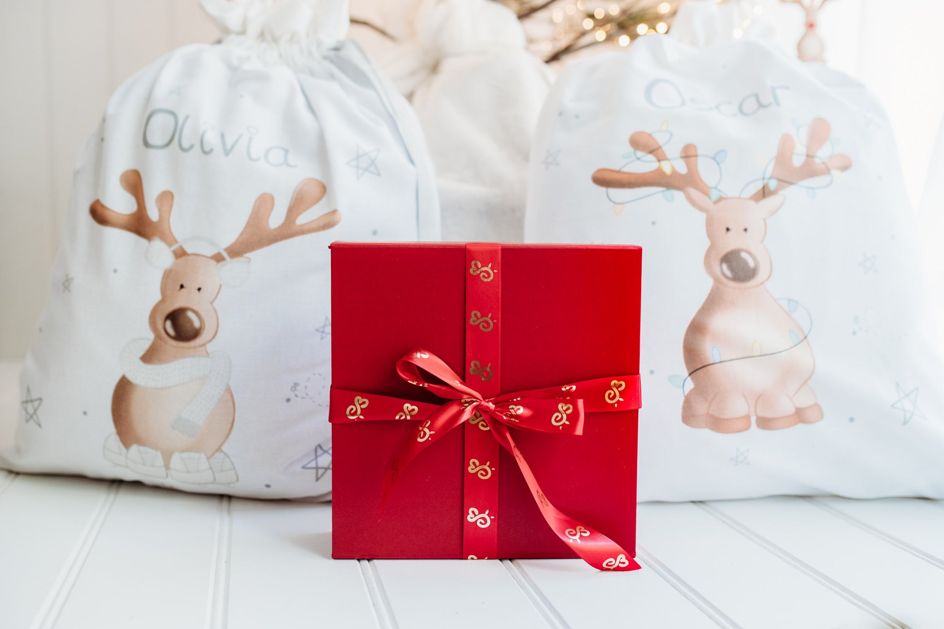 luxury red magnetic gift box wrapped in bumbleberry park sating ribbon under a christmas tree