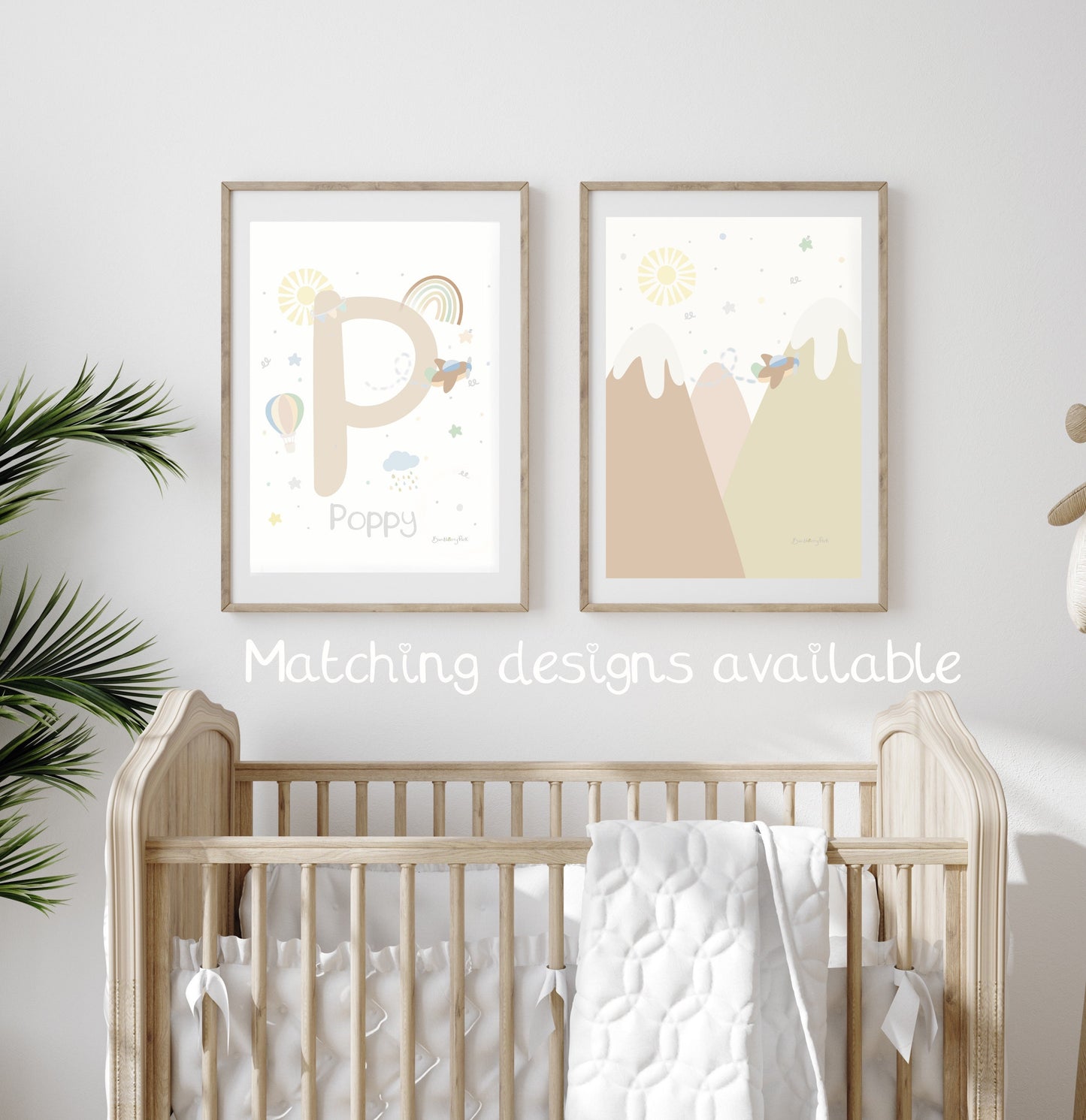 go explore adventure art print and baby name print and initial print in neutral tones in a light wood frame in a baby's nursery with hot air balloon, rainbow and aeroplane travel theme